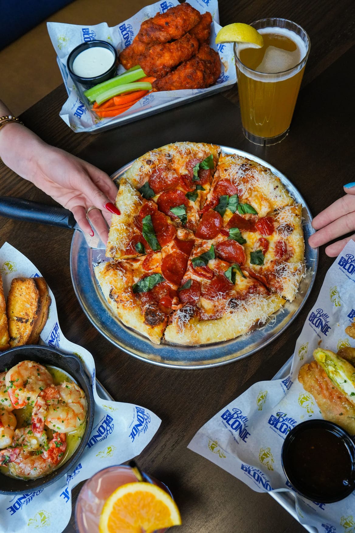 Pizza with wings shrimp and drinks bottled blonde